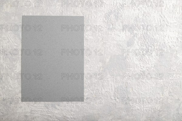 Gray paper business card, mockup on gray concrete background. Blank, flat lay, top view, still life, copy space