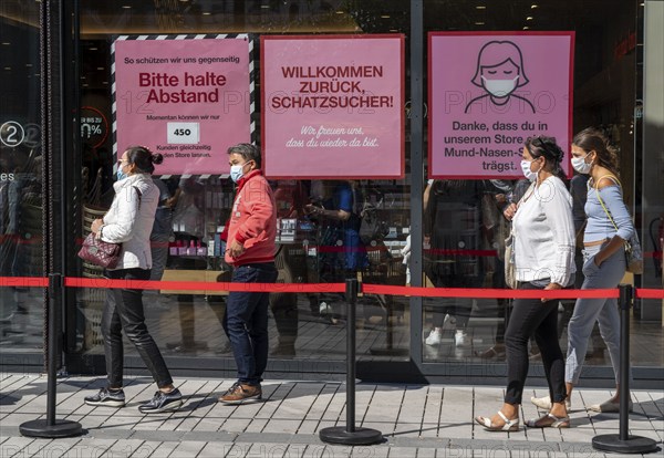 Queue in front of a clothing shop, Corona protective measures, posters for compulsory masks, distance, Düsseldorf, North Rhine-Westphalia, Germany, Europe
