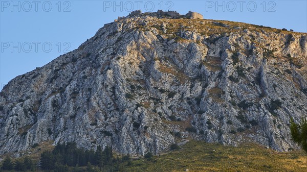 The golden hour illuminates a mountain with an ancient castle at the top, Archaic Castle, Akrokorinthos, Corinth, Peloponnese, Greece, Europe