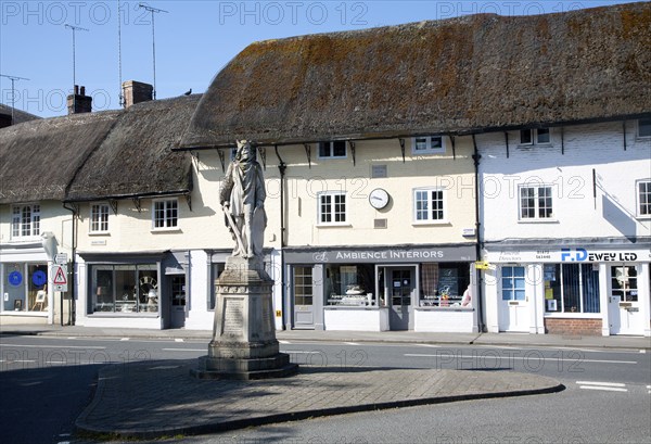 King Alfred statue in the market place and thatched shop buildings in the village of Pewsey, Wiltshire, England, United Kingdom, Europe