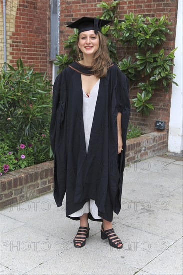 Full length portrait smiling young woman graduating, Goldsmiths College, University of London, England, UK