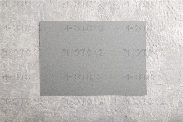 Gray paper business card, mockup on gray concrete background. Blank, flat lay, top view, still life, copy space