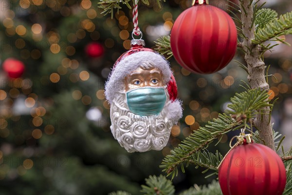 Symbolic image of Christmas in the Corona crisis, Father Christmas figure, Christmas tree decoration, with mouth and nose mask, everyday mask
