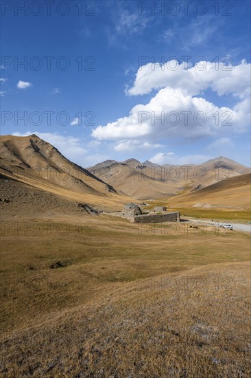 Historic caravanserai Tash Rabat from the 15th century, in the evening light with golden hills, Naryn region, Kyrgyzstan, Asia