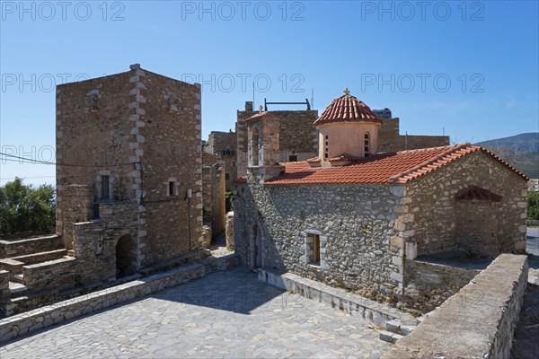 Traditional stone village buildings with red tiled roof under a blue sky, residential tower and church of Agios Spyridon, St Spyridon, Vathia, Ithylo, Anatoliki Mani, Mani, Laconia, Peloponnese, Greece, Europe