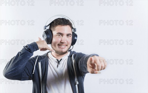 Young telemarker making call gesture on isolated background. Guy with headphones making a call me gesture isolated