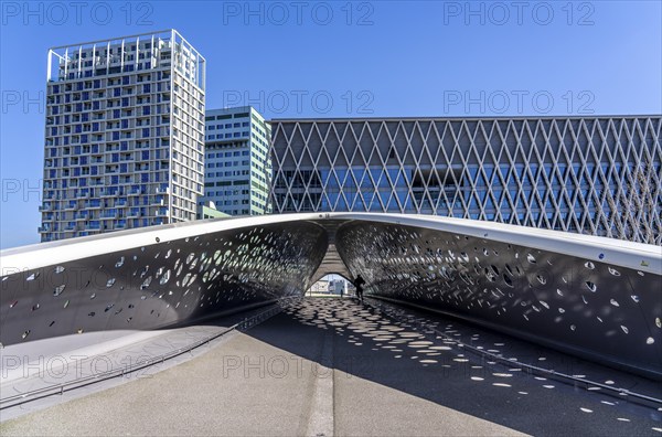 The Parkbruk, cycle and pedestrian bridge in the city centre of Antwerp, crosses a multi-lane city centre road, with tram lines, and thus connects two lively city districts Kop Spoor Noord and Eilandje, light effects by the sun, on the roadway, Belgium, Europe