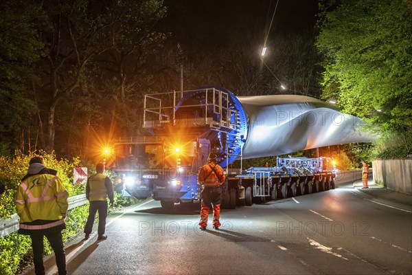 Transport of a 68 metre long, 22 tonne blade of a wind turbine, here in Schwelm, with a self-propelled Blade-Lifter vehicle, over a 40 km long route, over 2 nights, in the Bergisches Land, through towns, villages, over country roads, narrow through roads, to the construction site of the wind turbine near Hagen, North Rhine-Westphalia, Germany, Europe
