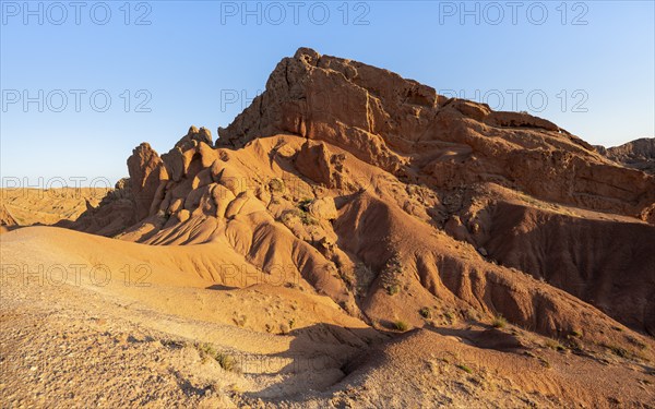 Erosion landscape of red and yellow sandstone, rock formations at sunrise, Skazka Canyon, fairytale gorge, Tosor, Kyrgyzstan, Asia