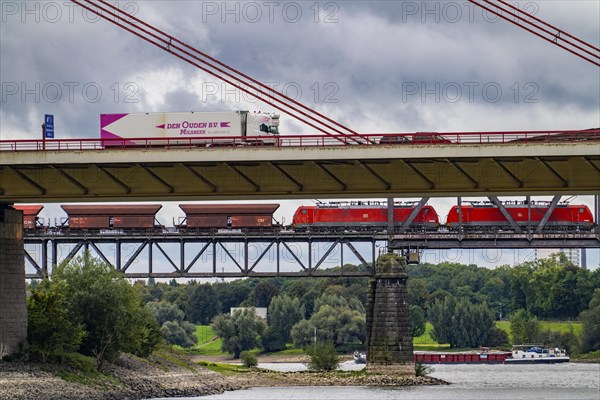 The Beeckerwerth Rhine bridge of the A42 motorway, truck traffic, in front of it the Haus-Knipp railway bridge, goods train, cargo ship on the Rhine near Duisburg, North Rhine-Westphalia, Germany, Europe