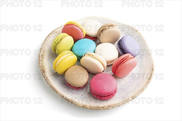 Multicolored macaroons on ceramic plate isolated on white background. side view, still life, close up. Breakfast, morning, concept