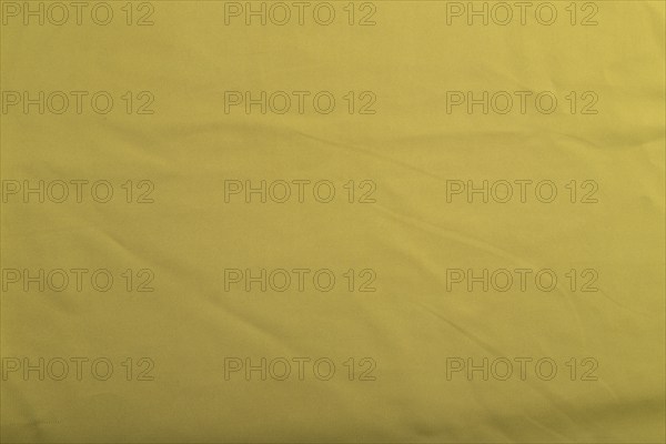 Fragment of smooth green olive silk tissue. Top view, flat lay, natural textile background and texture