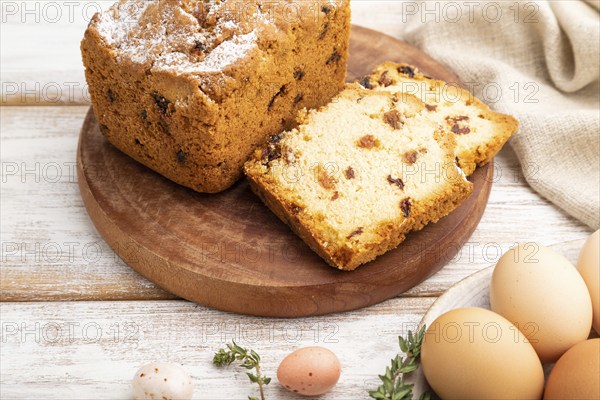 Homemade easter pie with raisins and eggs on plate on a white wooden background and linen textile. side view, close up