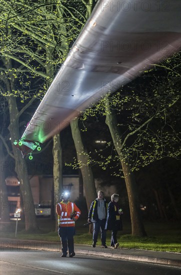 Transport of a 68 metre long, 22 tonne blade of a wind turbine, here in Schwelm, with a self-propelled Blade-Lifter vehicle, over a 40 km long route, over 2 nights, in the Bergisches Land, through towns, villages, over country roads, narrow through roads, to the construction site of the wind turbine near Hagen, North Rhine-Westphalia, Germany, Europe