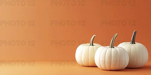 Three white pumpkins on orange background with copy space. Generative Ai, AI generated