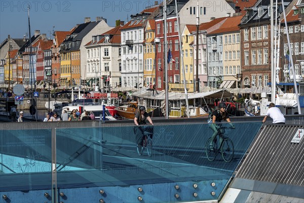Cyclists on the Inderhavnsbroen cycle and footpath bridge, over the harbour, at Nyhavn, Copenhagen is considered the cycling capital of the world, 45 % of the population travel by bike, Denmark, Europe