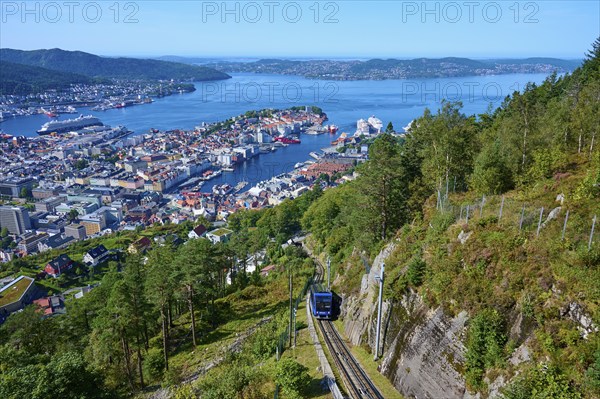 Panoramic view of Bergen with harbour on a clear day, cable car ascending the wooded mountain, Fløibanen mountain station, Bergen, Vestland, Norway, Europe