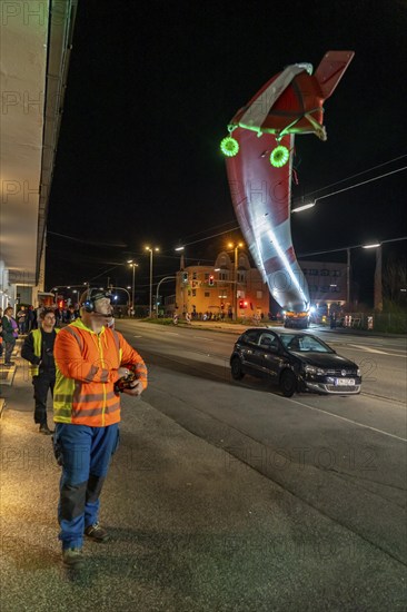 Transport of a 68 metre long, 22 tonne blade of a wind turbine, here in Schwelm, with a self-propelled Blade-Lifter vehicle, over a 40 km long route, over 2 nights, in the Bergisches Land, through towns, villages, over country roads, narrow through roads, to the construction site of the wind turbine near Hagen, North Rhine-Westphalia, Germany, Europe