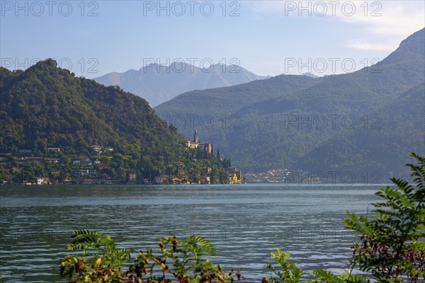 Church Santa Maria del Sasso with Trees Branches on the Mountain Side and Lake Lugano in Morcote, Ticino, Switzerland, Europe