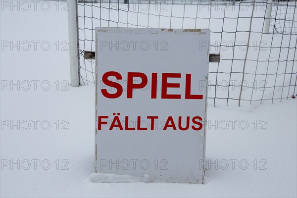 Symbolic image of a football match cancelled due to snow. Sign on a sports field with the inscription GAME CANCELLED