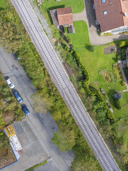 Aerial view of a railway track through a residential area with neighbouring streets and gardens, tamping machine, Hermann Hessebahn, Althengstett, Black Forest, Germany, Europe