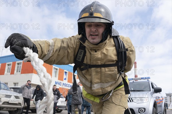PETROPAVLOVSK CITY, KAMCHATKA PENINSULA, RUSSIA, APR 19, 2019: Firefighter-rescuer Emercom of Russia towing car with rope over distance of 50 meters. Firefighters and rescuers sport competitions