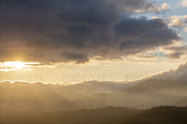 Mist in the mountains in autumn. The evening sun lights up the valleys. France Europe, Vosges