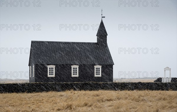 Famous picturesque black church of Budir at Snaefellsnes peninsula region in Iceland during a heavy snowy weather
