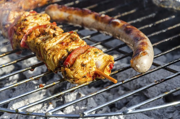 Chicken skewer and sausage on a barbecue grill