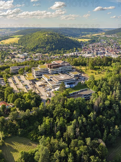 Aerial view of a town in green surroundings, many houses and a large building on a hill, blue summer sky, hospital, Nagold, Black Forest, Germany, Europe