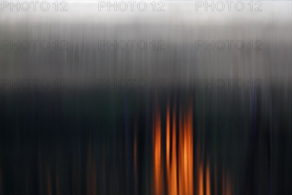 Abstract vertical lines with dark tones and orange-coloured accents, foggy mood over the water at sunset on the Peene River, Flusslandschaft Peenetal nature park Park, Mecklenburg-Western Pomerania, Germany, Europe