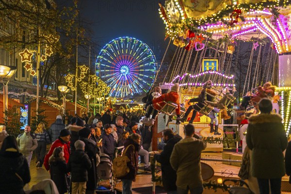 Christmas market on Königsstraße in the city centre of Duisburg, pre-Christmas season, Christmas lights, Ferris wheel, chain carousel, Christmas market stalls, crowds, North Rhine-Westphalia, Germany, Europe