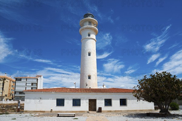 White lighthouse with neighbouring building under blue sky with clouds, sunny atmosphere, Faro de Torrox, Torrox, Málaga province, Malaga, Andalusia, Spain, Europe