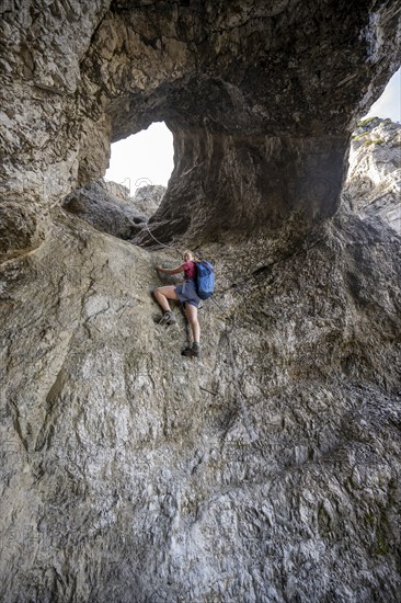 Hiker climbing through the Schindertor, Schinder, Tegernsee mountains in the Mangfall mountains, Germany, Europe