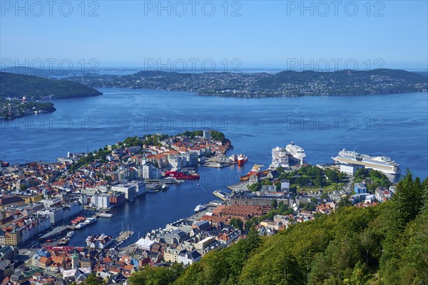Panoramic view of a coastal town with harbour and a variety of buildings, surrounded by mountains and water under a clear sky, Fløibanen mountain station, Bergen, Vestland, Norway, Europe