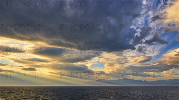 Dramatic sky over the sea with sun rays breaking through the clouds, Cape Melagkavi, Gulf of Corinth, Corinth, Peloponnese, Greece, Europe