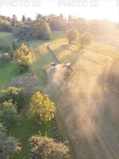 Picturesque fields at sunset, where machines stir up dust during the harvest, Haselstaller Hof, Gechingen, Black Forest, Germany, Europe