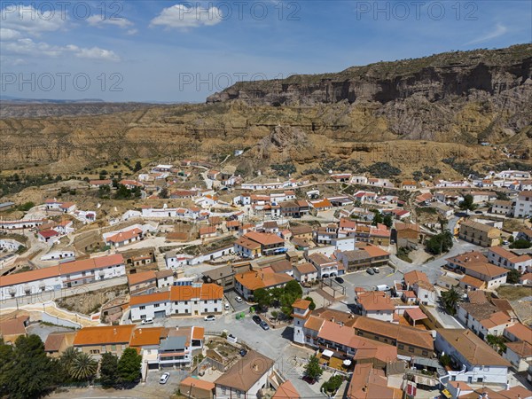 Small village with white houses and red roofs in a rocky hilly landscape under a blue sky, aerial view, Gorafe, Guadix, Granada, Andalusia, Spain, Europe