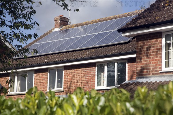 Large array of solar panels on domestic house roof