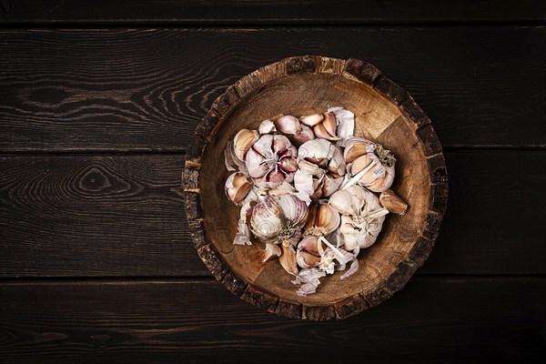 Fresh garlic, in a wooden plate, top view, close-up, no people