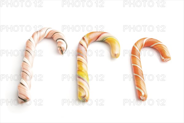 Three christmas cane candies isolated on white background. close up, side view