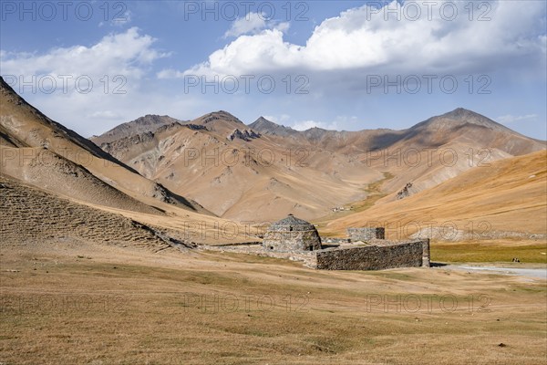 Historic caravanserai Tash Rabat from the 15th century, with yellow hills, Atbashy district in the Naryn region, Kyrgyzstan, Asia