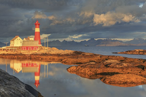Lighthouse reflected in water, morning light, clouds, mountains, coast, Tranoy, Ofoten, Norway, Europe