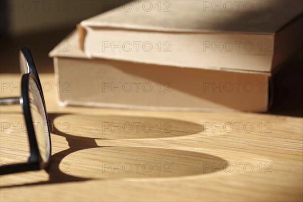 Symbolic image reading, glasses, shadow, glass, books, reading, reflection, In the light of the sun, shadows of glasses fall on a table top. Two books lie in the background