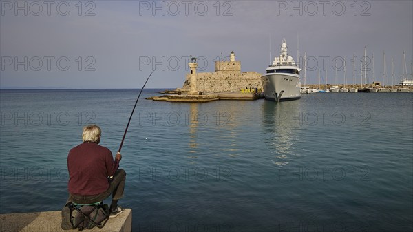 A Fish at a harbour with a clear view of a fortress and a standing yacht during the day, Fort of Saint Nikolaos, harbour area, Rhodes Town, Rhodes, Dodecanese, Greek Islands, Greece, Europe