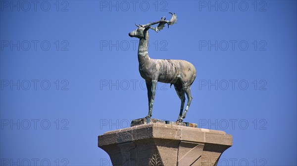 Bronze deer statue on a pedestal in front of a clear blue sky, Mandraki harbour, harbour area, Rhodes town, Rhodes, Dodecanese, Greek Islands, Greece, Europe