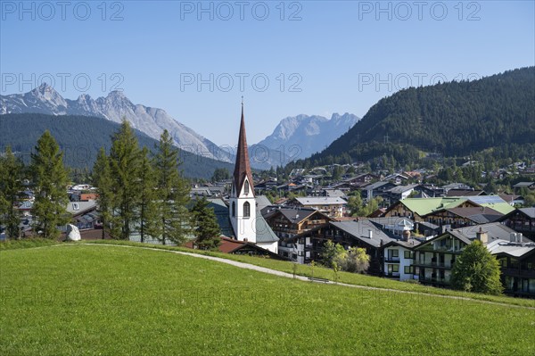 View of the village with St Oswald parish church, Karwendel mountains, view from the parish hill, Seefeld, Tyrol, Austria, Europe