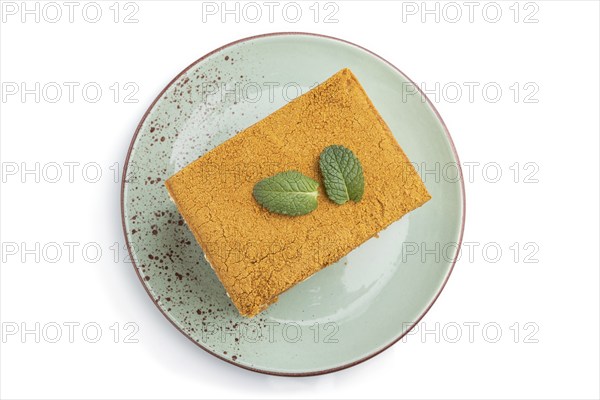 Homemade honey cake with milk cream and mint isolated on white background. Top view, close up, flat lay