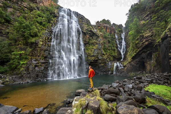 Young man standing in front of a waterfall, Lisbon Falls, long exposure, near Graskop, Mpumalanga, South Africa, Africa