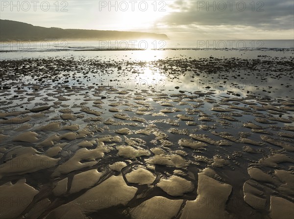 Sunrise at low tide at the shore of the Atlantic Ocean near Cape Trafalgar. Aerial view. Drone shot. Costa de la Luz, Cádiz province, Andalusia, Spain, Europe